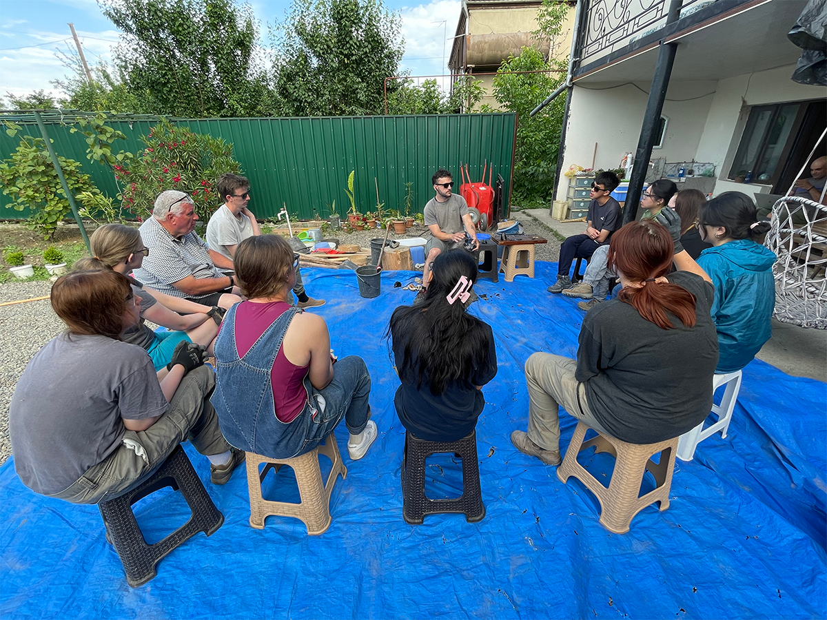 Group of students and volunteers learning to make stone tools from obsidian by staff member 